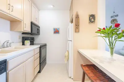 a kitchen with a sink and a refrigerator at Marbella Lane - Bayfront Bliss Sunset Views w Pool in San Diego