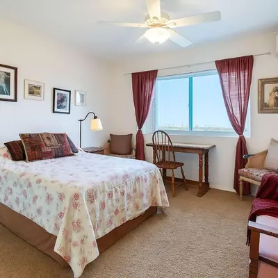 a bedroom with a bed and a table and a window at Marbella Lane - Bayfront Bliss Sunset Views w Pool in San Diego
