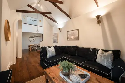 a living room with a black couch and a table at Walk to La Jolla Shores 2 homes Luxury Villa in San Diego
