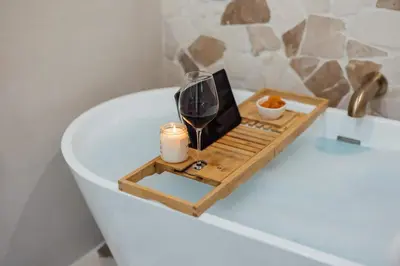 a tray with a glass of wine and a candle in a bath tub at Palm Grove Luxe King, Wet Room & Chefs Kitchen in Carlsbad