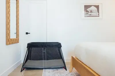 a bed in a room next to a white wall at Palm Grove Luxe King, Wet Room & Chefs Kitchen in Carlsbad