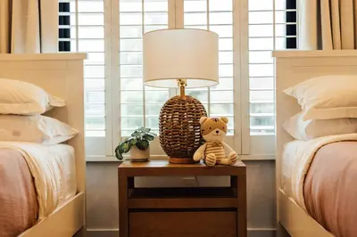 a lamp on a table in a bedroom with two beds at Palm Grove Luxe King, Wet Room & Chefs Kitchen in Carlsbad
