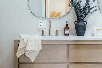 a bathroom sink with a vase and a mirror at Palm Grove Luxe King, Wet Room & Chefs Kitchen in Carlsbad