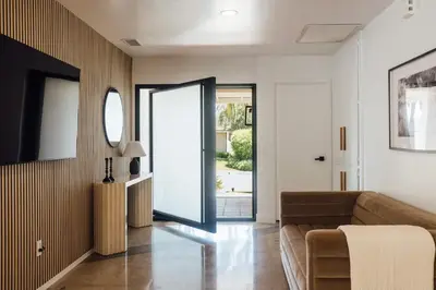 a living room with a couch and a sliding glass door at Palm Grove Luxe King, Wet Room & Chefs Kitchen in Carlsbad