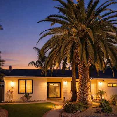 a palm tree in front of a house at Palm Grove Luxe King, Wet Room & Chefs Kitchen in Carlsbad