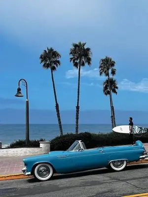 an old blue car parked on the street with a surfboard at Seaglass 222 in San Clemente