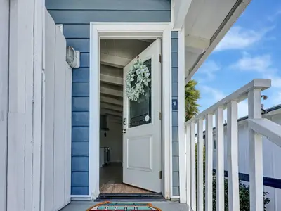 a white door on a blue house with a wreath at Seaglass 222 in San Clemente