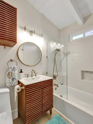 a bathroom with a sink and a tub and a mirror at Seaglass 222 in San Clemente
