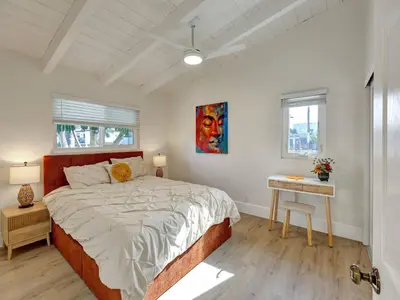 a bedroom with a large bed and a table at Seaglass 222 in San Clemente