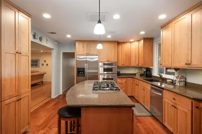 a kitchen with wooden cabinets and stainless steel appliances at Pool Oasis Central Villa in El Cajon