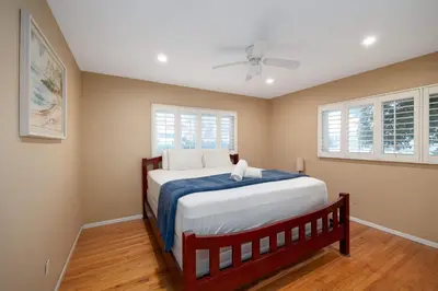 a bedroom with a bed and two windows at Pool Oasis Central Villa in El Cajon