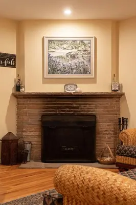 a living room with a fireplace with a picture above it at Pool Oasis Central Villa in El Cajon