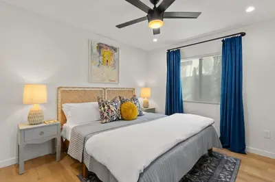 a bedroom with a bed and a ceiling fan at Newly Remodeled OB Beach house walk to all Parking in San Diego