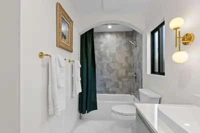 a white bathroom with a toilet and a shower at Newly Remodeled OB Beach house walk to all Parking in San Diego