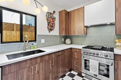 a kitchen with wooden cabinets and a sink at Newly Remodeled OB Beach house walk to all Parking in San Diego