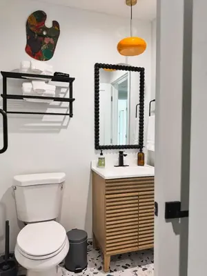 a bathroom with a toilet and a mirror at Newly Remodeled OB Beach house walk to all Parking in San Diego