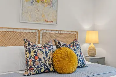 a bedroom with a bed with pillows and a yellow pillow at Newly Remodeled OB Beach house walk to all Parking in San Diego