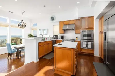 a large kitchen with wooden cabinets and a table at Ocean View 4 Bedroom Home in Carlsbad