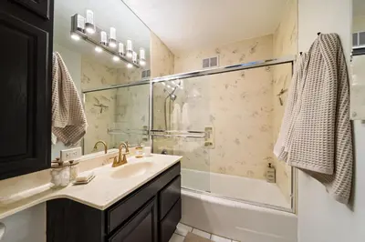 a bathroom with a sink and a glass shower at La Jolla Studio - Private Beach in San Diego