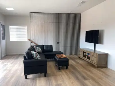 a living room with a black couch and a television at Harbor View Haven by Balboa Park in San Diego