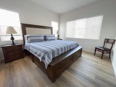 a bedroom with a bed and a chair in it at Harbor View Haven by Balboa Park in San Diego