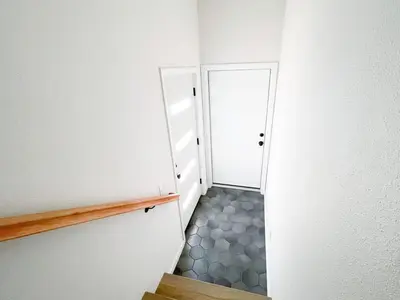 a hallway with two white doors and a tile floor at Harbor View Haven by Balboa Park in San Diego