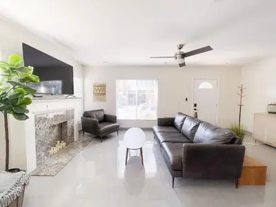 a living room with a leather couch and a fireplace at Central Charm in Hillcrest near Scripps Mercy in San Diego