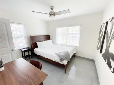 a white bedroom with a bed and a table at Central Charm in Hillcrest near Scripps Mercy in San Diego
