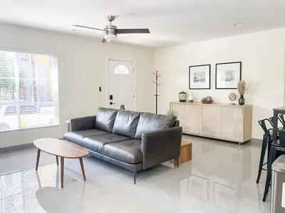 a living room with a leather couch and a table at Central Charm in Hillcrest near Scripps Mercy in San Diego