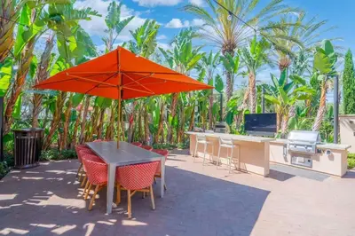 a table and chairs with an orange umbrella on a patio at Elegant New 2BR Luxury Home in Irvine in Lake Forest