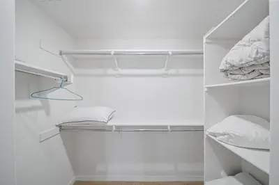 a white closet with white shelves and white towels at Elegant New 2BR Luxury Home in Irvine in Lake Forest