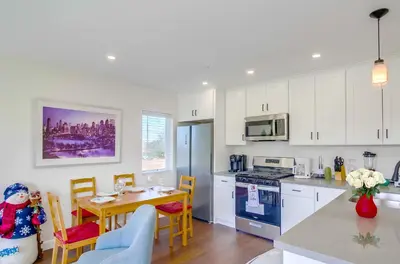 a kitchen with white cabinets and a table and a dining room at Entire Private Home with 3 Bedrooms 3 Bathrooms, Near San Diego Downtown & Beach, Available Now in National City