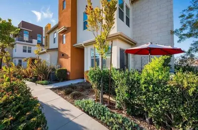 an umbrella and bushes in front of a house at Beautiful Spacious Condo in an Excellent Location in Chula Vista