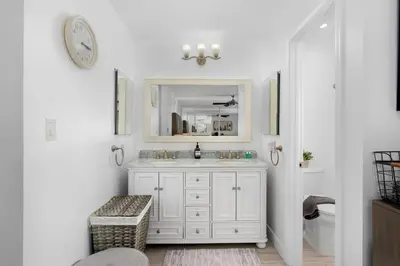 a white bathroom with a sink and a mirror at Amazing Pool Side View of SeaWorld & the Ocean in San Diego