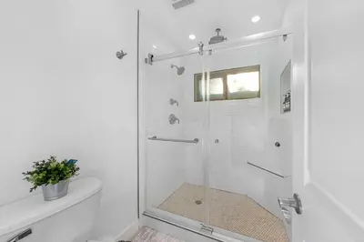 a white bathroom with a shower with a glass door at Amazing Pool Side View of SeaWorld & the Ocean in San Diego