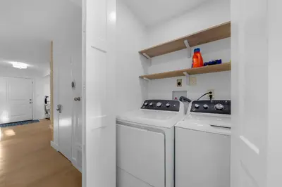 a white kitchen with a stove and a dishwasher at Amazing Pool Side View of SeaWorld & the Ocean in San Diego