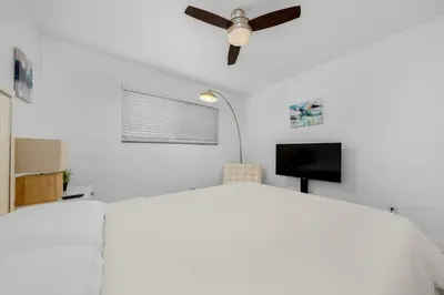 a bedroom with a ceiling fan and a tv at Amazing Pool Side View of SeaWorld & the Ocean in San Diego