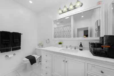 a white bathroom with a sink and a mirror at Amazing Pool Side View of SeaWorld & the Ocean in San Diego