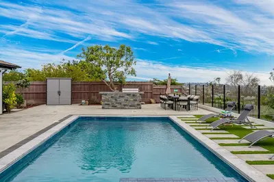a swimming pool in a backyard with a table and chairs at Amazing Pool Side View of SeaWorld & the Ocean in San Diego