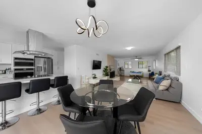 a kitchen and living room with a glass table and chairs at Amazing Pool Side View of SeaWorld & the Ocean in San Diego