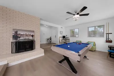 a living room with a pool table and a fireplace at Amazing Pool Side View of SeaWorld & the Ocean in San Diego