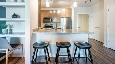a kitchen with three stools at a counter in a kitchen at Landing Stylish 1BD Yoga Studio Game Room in Murrieta