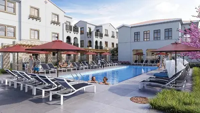 a pool with chairs and umbrellas next to a building at Landing Stylish 1BD Yoga Studio Game Room in Murrieta
