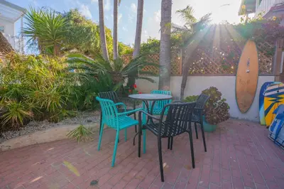 a patio with a table and chairs and a surfboard at Mission Casa Del Sol in San Diego