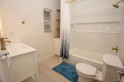 a white bathroom with a toilet and a shower at Mission Casa Del Sol in San Diego