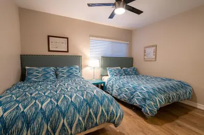 a bedroom with two beds and a ceiling fan at Mission Casa Del Sol in San Diego