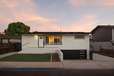 a white house with a driveway and a garage at Spacious & Newly Renovated Villa in San Diego - Perfect for Families in San Diego
