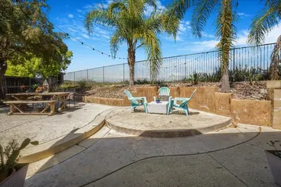 two chairs and a table in a patio with palm trees at Your Home Away From Home near Wineries & Old Town in Murrieta