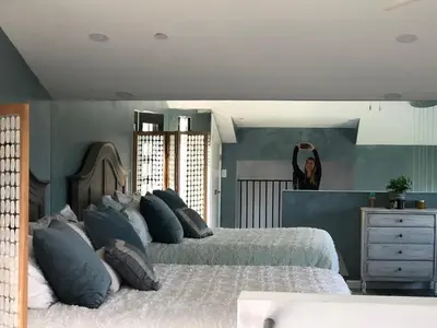 a woman is standing in a bedroom with two beds at LOVE SHACK on private canyon, minutes to the Beach in San Diego