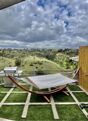 a hammock on a balcony with a view of a hill at LOVE SHACK on private canyon, minutes to the Beach in San Diego